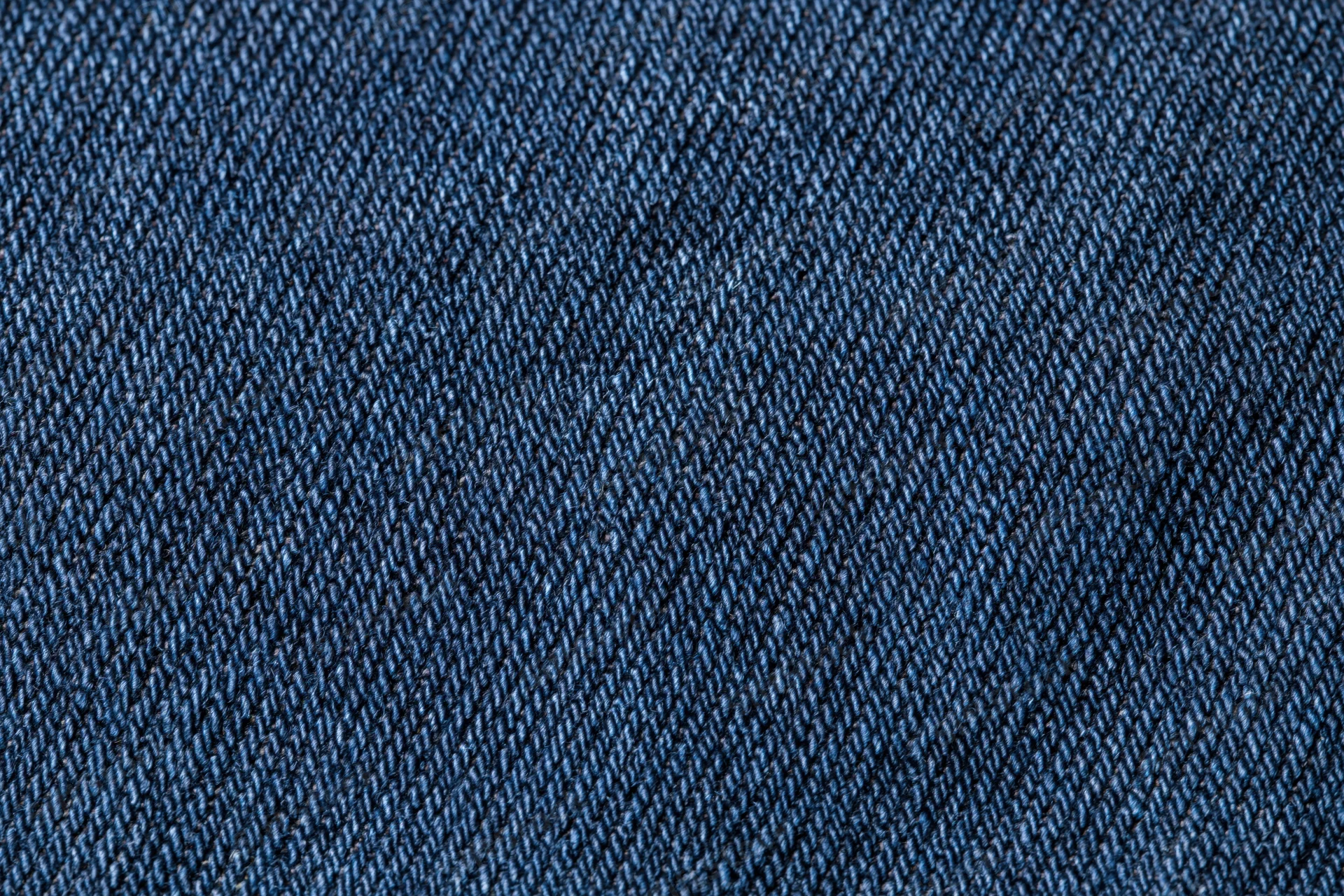 Close-up of dark indigo denim fabric with visible twill weave pattern