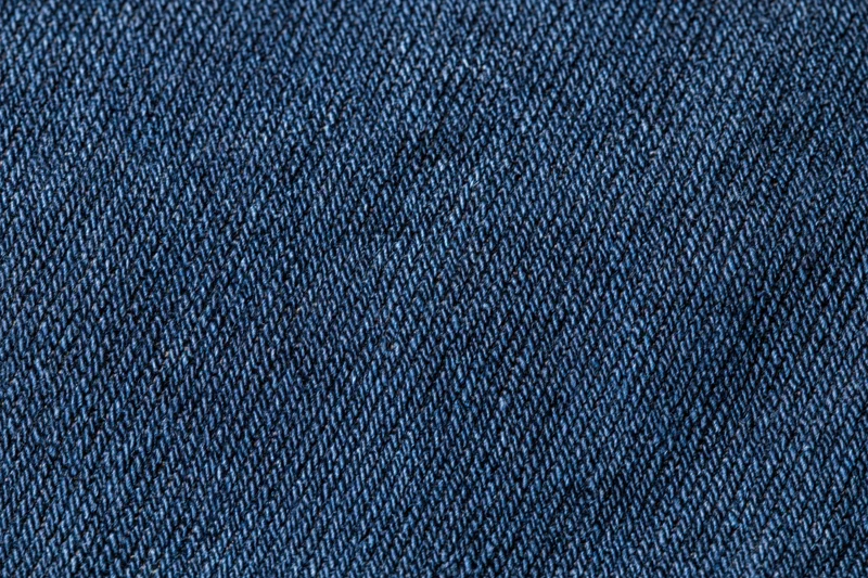Close-up of dark indigo denim fabric with visible twill weave pattern