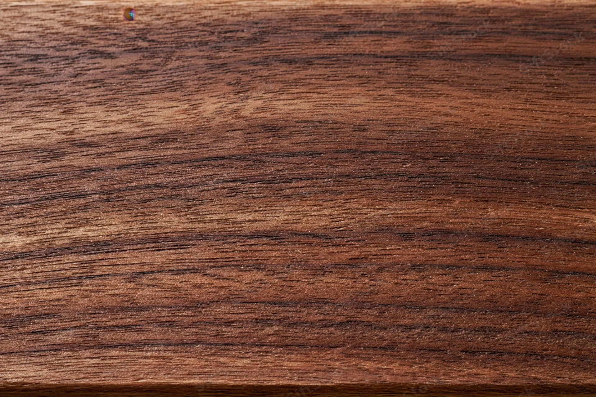 Close-up of dark walnut wood grain surface filling the frame