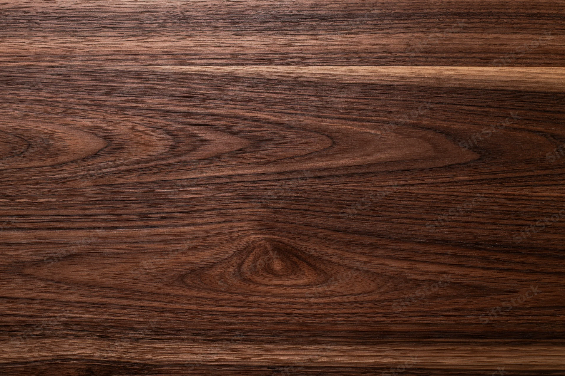 Close-up of dark walnut wood surface with visible grain pattern