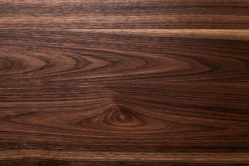 Close-up of dark walnut wood surface with visible grain pattern
