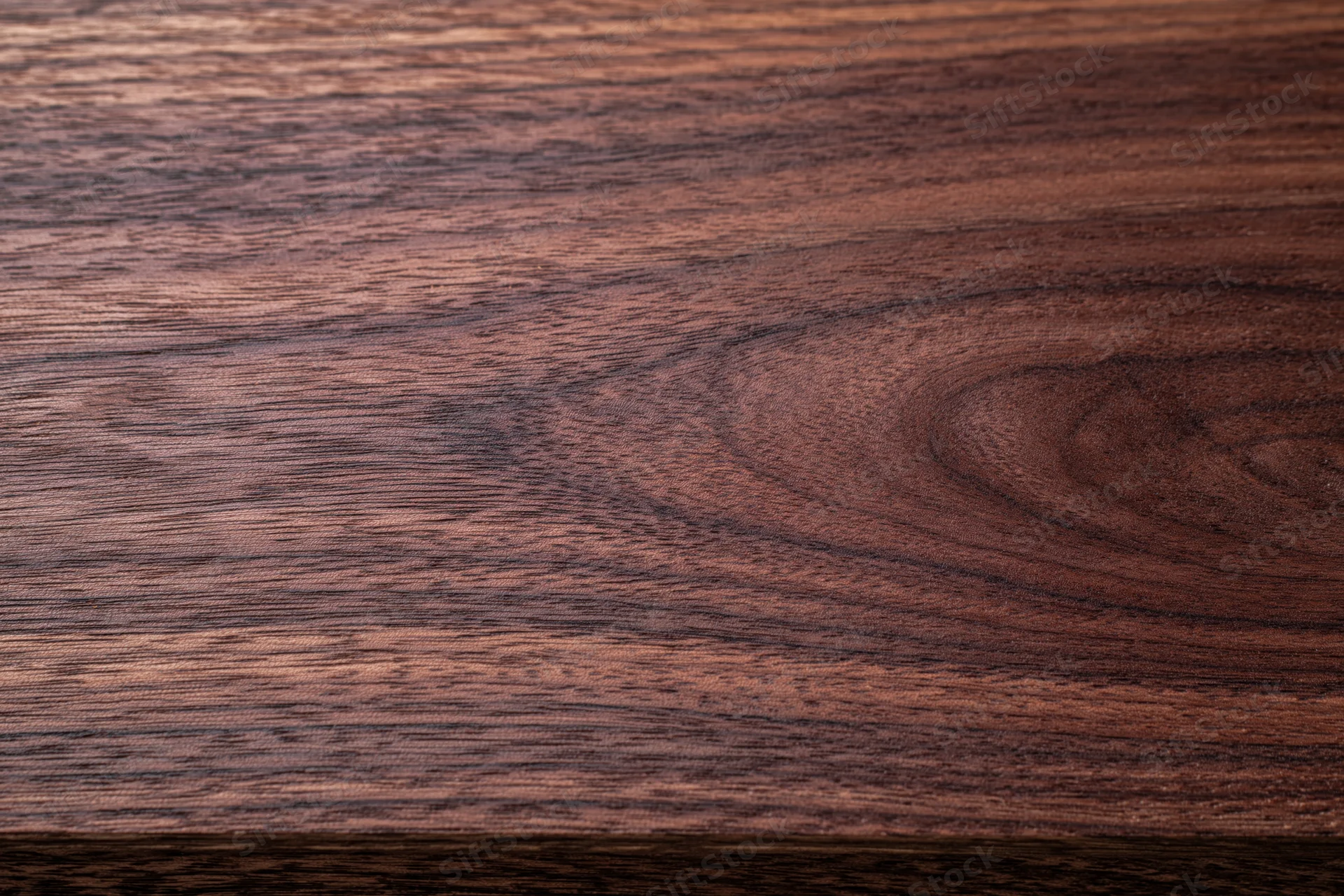 Close-up of dark walnut wood surface showing natural grain and texture