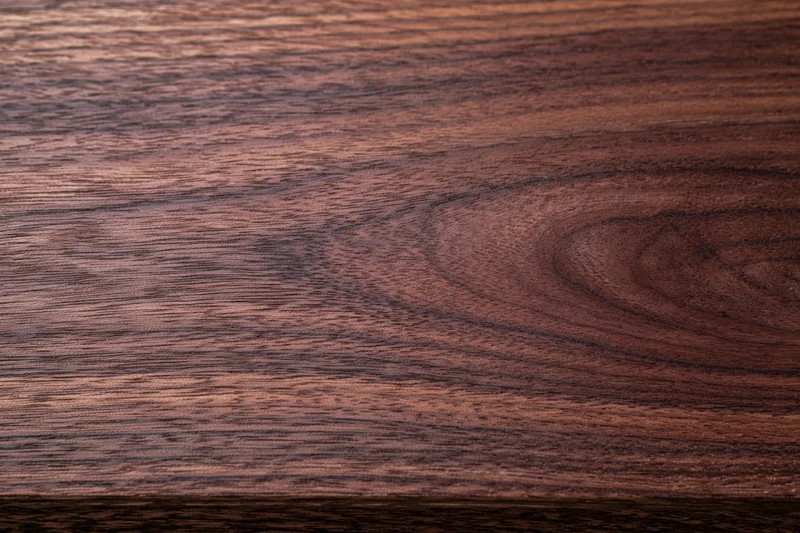 Close-up of dark walnut wood surface showing natural grain and texture