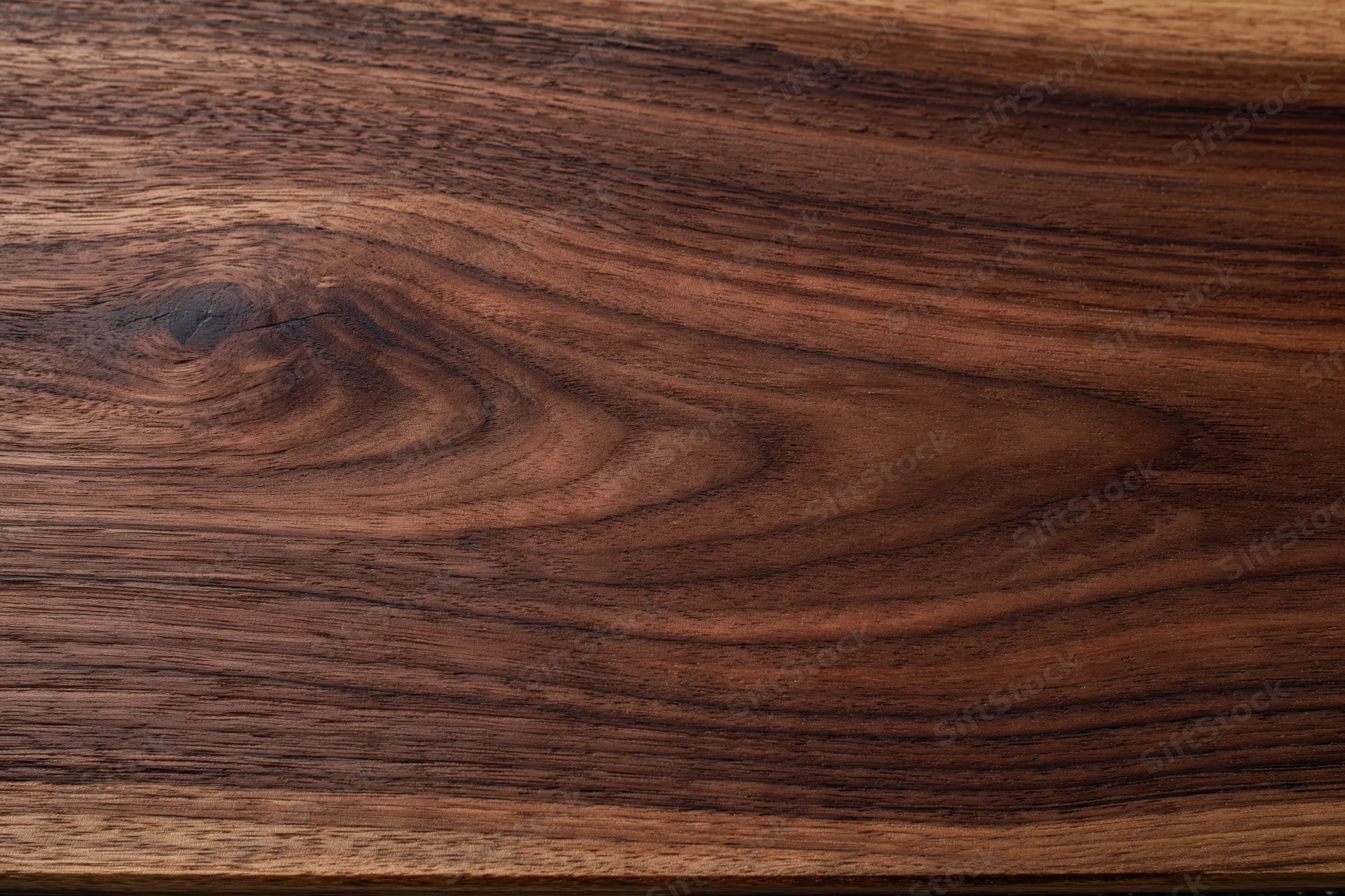 Close-up of dark walnut wood surface with visible grain and texture