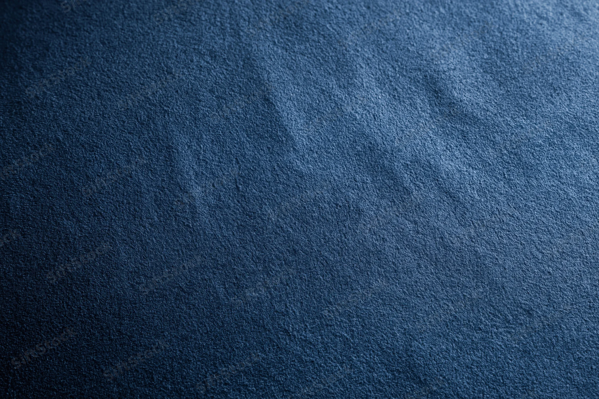 Close-up of deep navy blue suede fabric surface with visible texture and grain