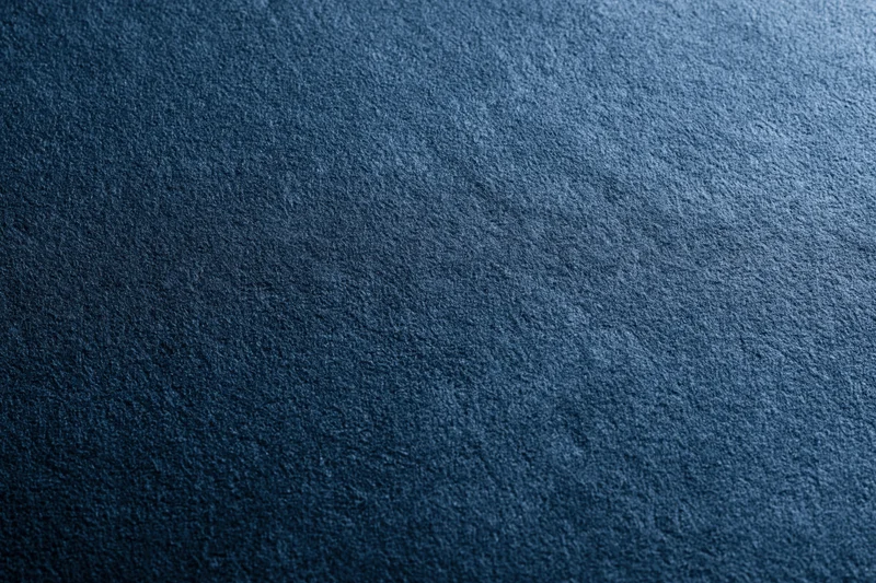Close-up of deep navy blue suede fabric surface with matte texture
