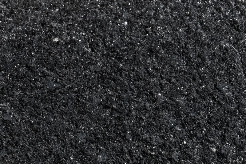 Close-up of polished black granite surface showing natural speckled texture