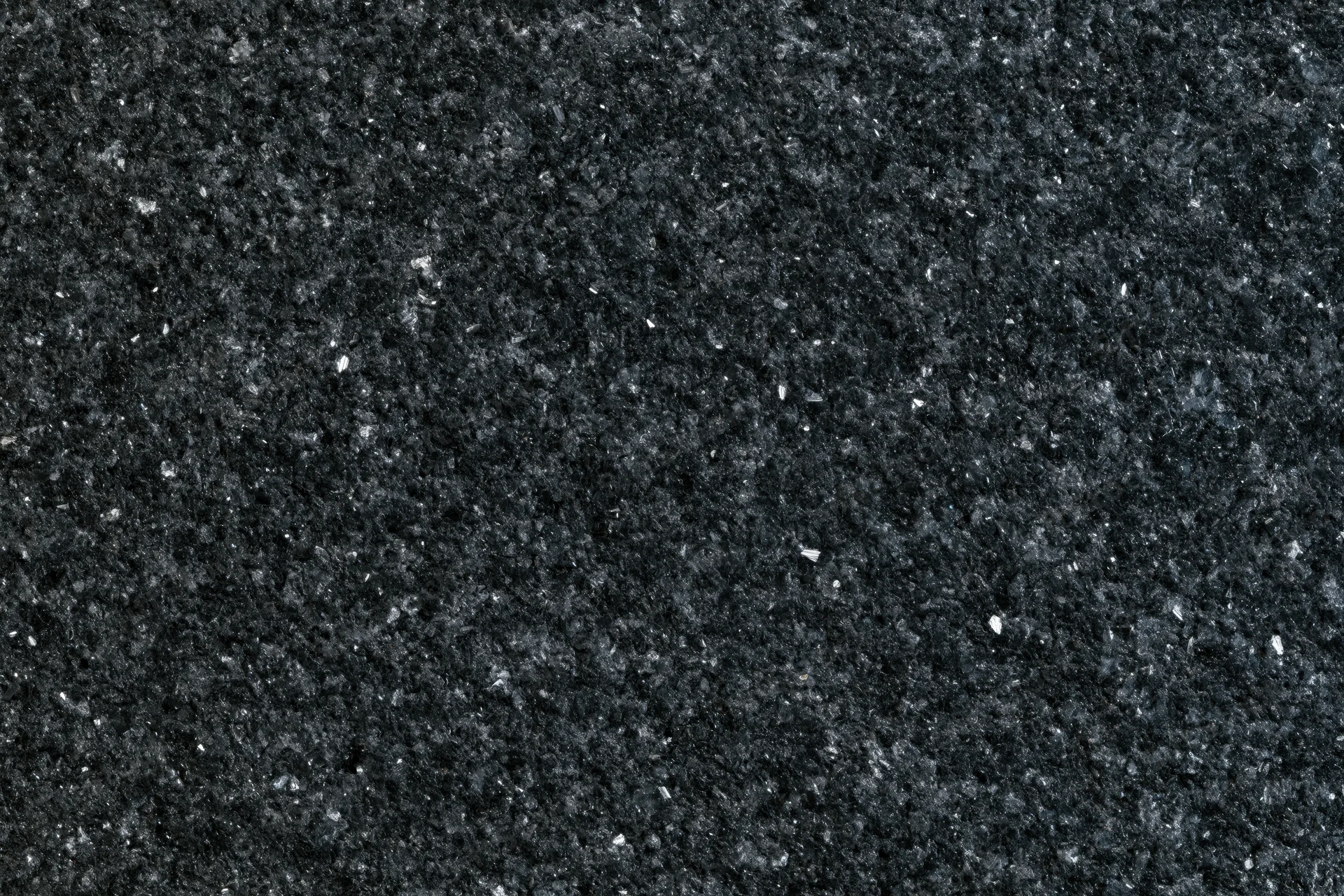 Close-up of polished black granite surface showing natural stone texture and speckled pattern
