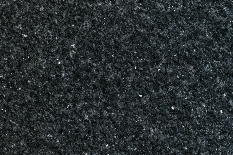 Close-up of polished black granite surface showing natural stone texture and speckled pattern