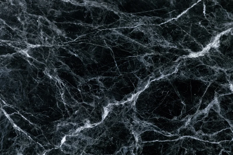 Close-up of polished black marble surface with white veining filling the frame