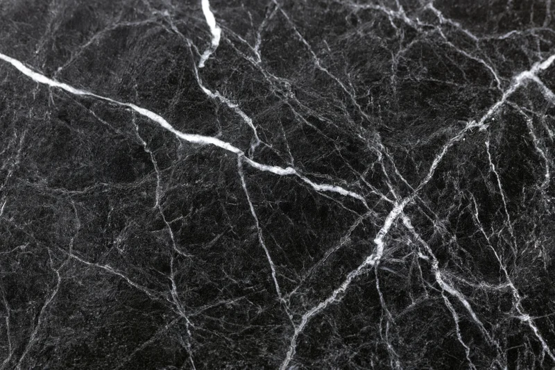 Close-up of polished black marble surface with white veining filling the frame