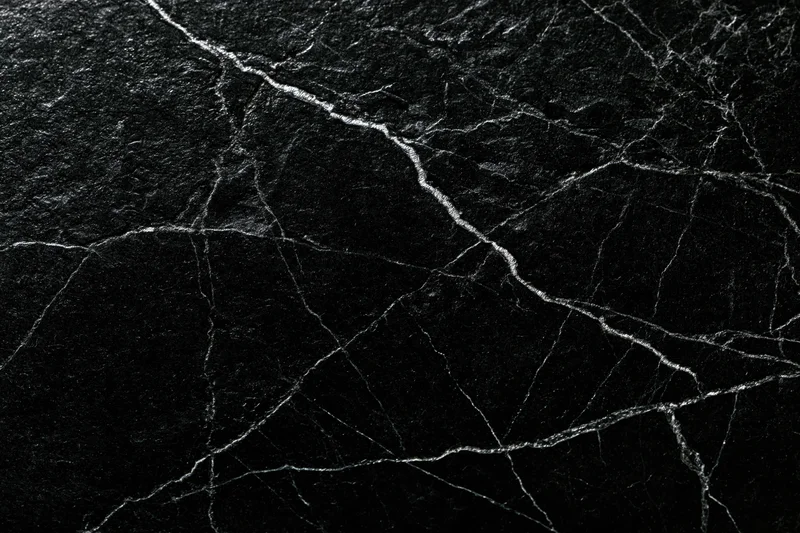 Close-up of polished black marble surface with white veining filling the frame