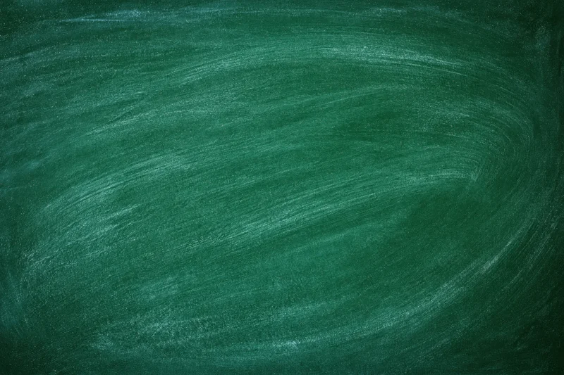Close-up of blank green chalkboard surface with faint chalk marks and texture