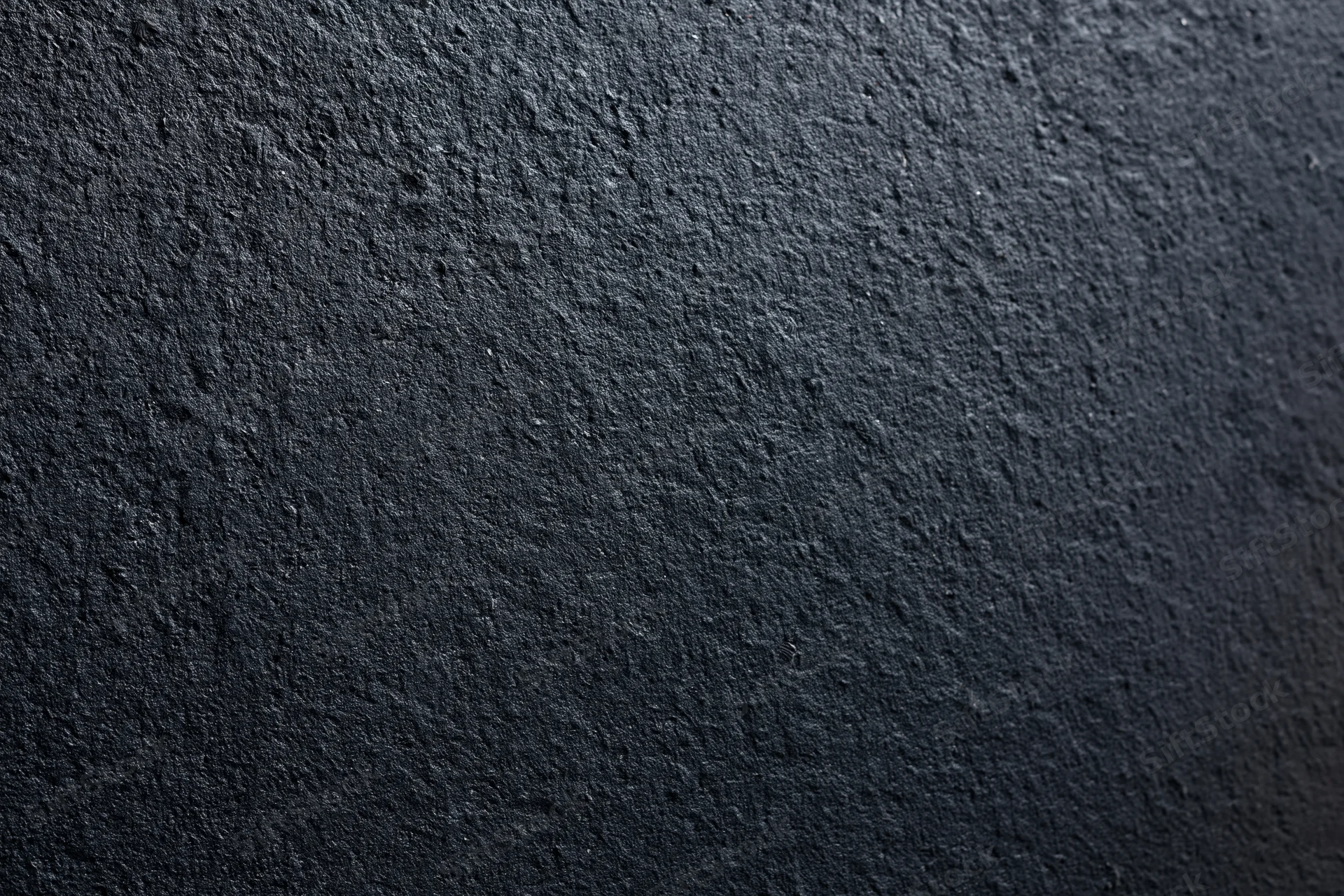 Close-up of dark charcoal concrete wall surface with rough texture