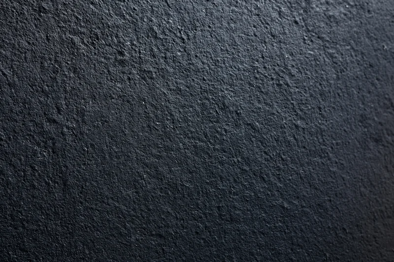 Close-up of dark charcoal concrete wall surface with rough texture