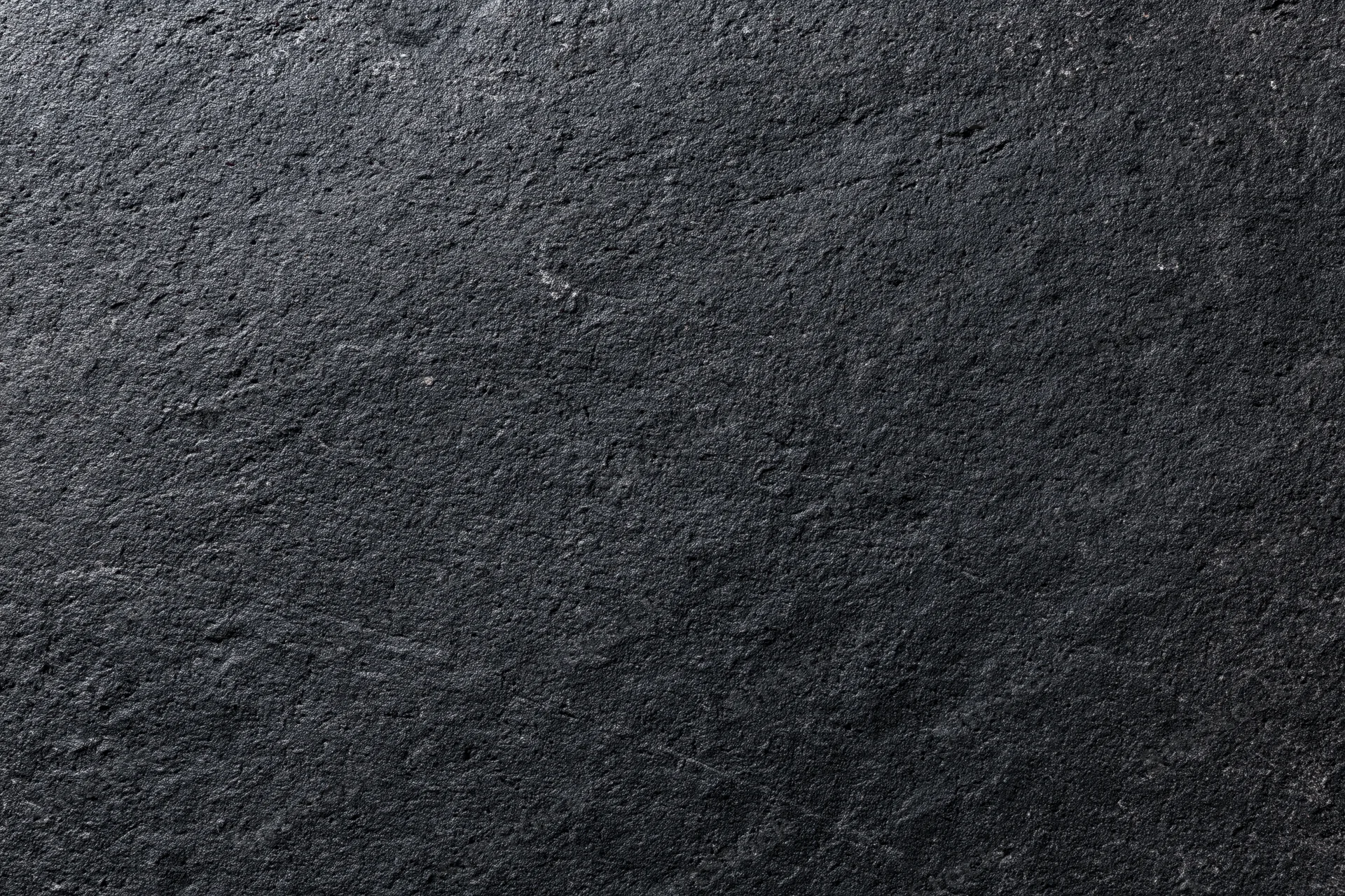 Close-up of dark charcoal concrete wall surface with rough texture