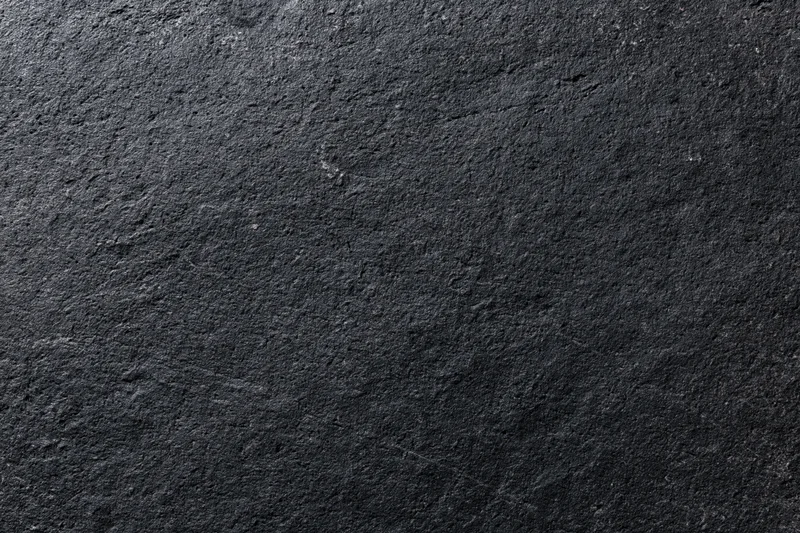 Close-up of dark charcoal concrete wall surface with rough texture