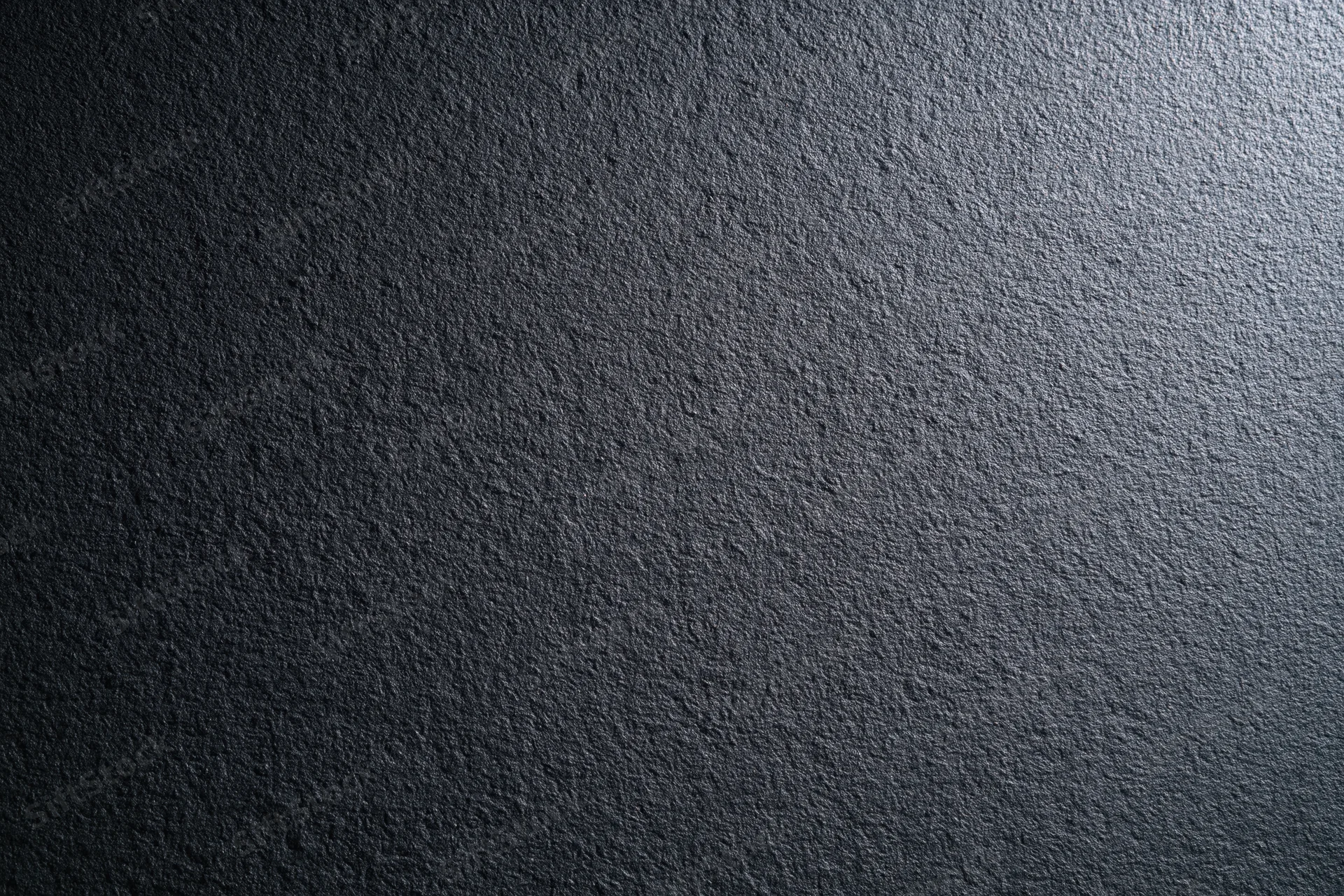 Close-up of dark charcoal matte wall surface with rough texture