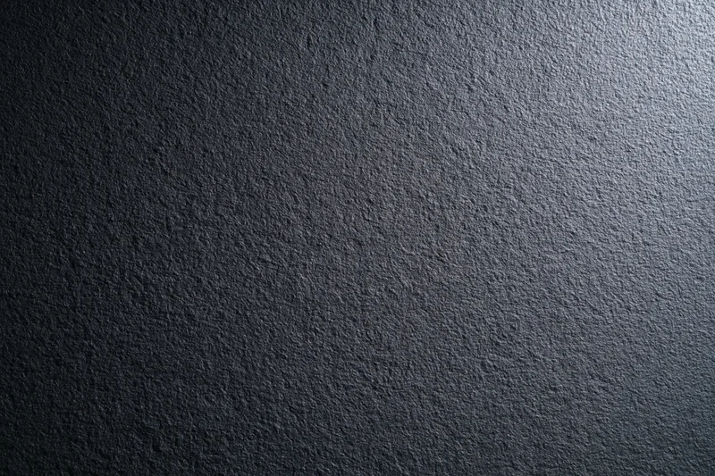 Close-up of dark charcoal matte wall surface with rough texture