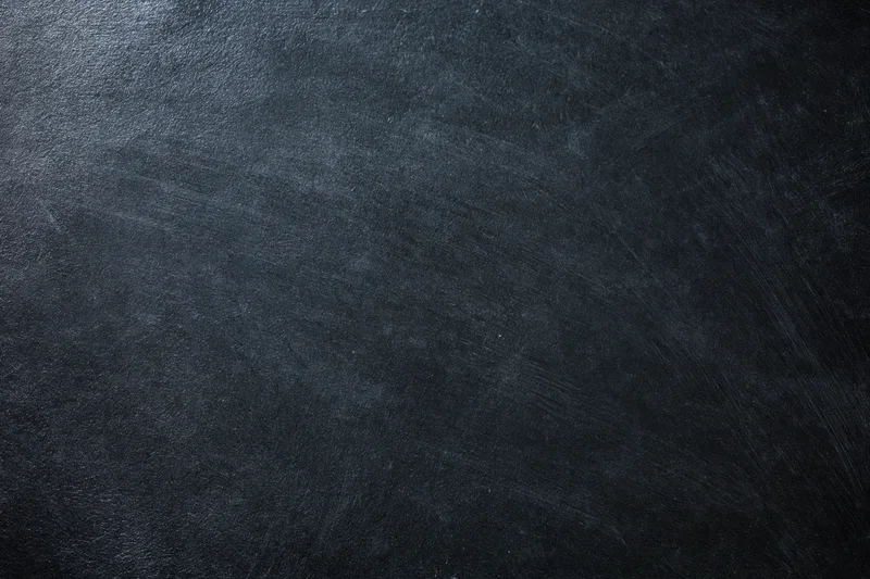 Close-up of a dark charcoal textured surface with subtle grain and matte finish