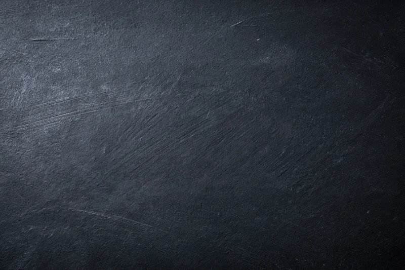 Dark textured slate surface in close-up flat view