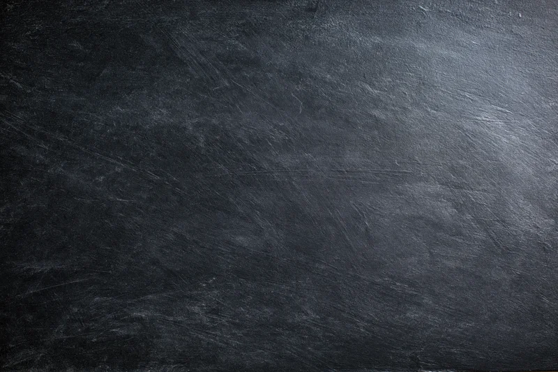 Close-up of dark textured slate surface with natural grain and scratches