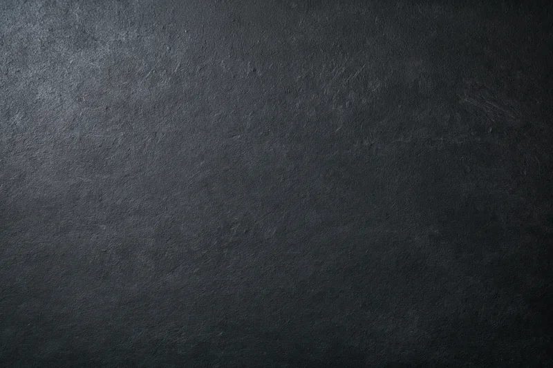 Close-up of dark charcoal textured surface filling the frame