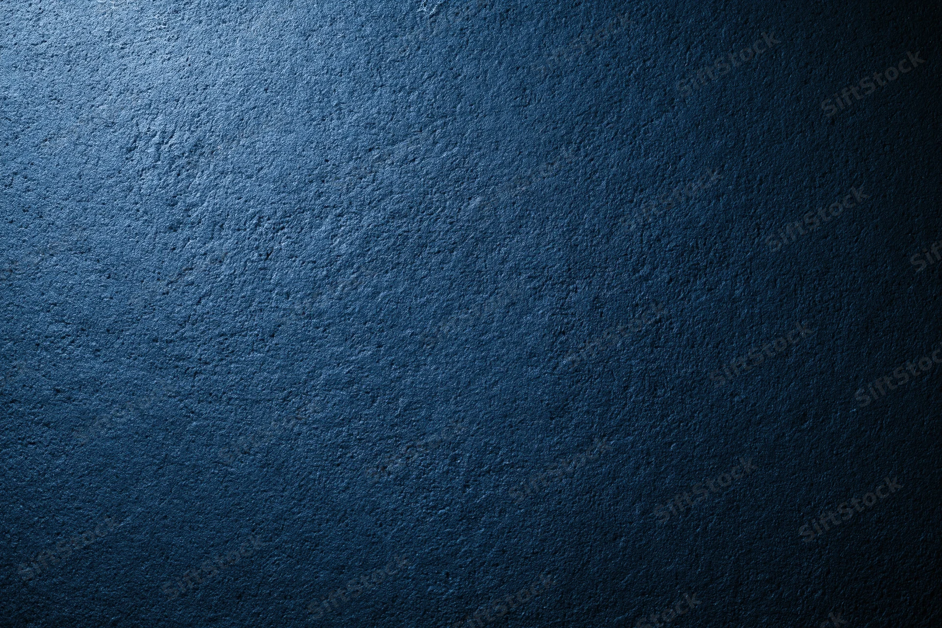 Dark navy blue textured wall surface with subtle lighting gradient