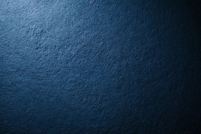 Dark navy blue textured wall surface with subtle lighting gradient