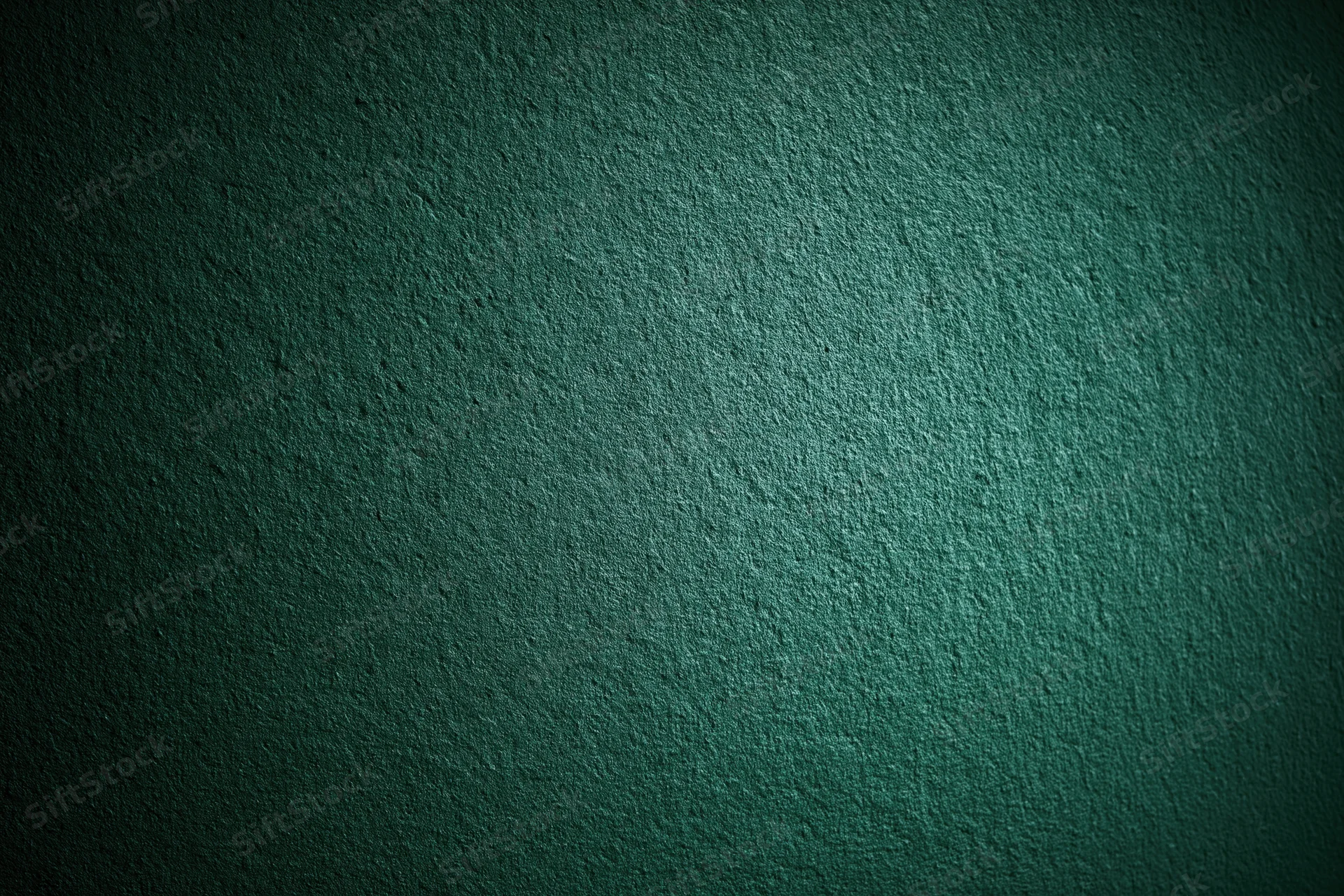 Close-up of a deep forest green textured wall surface with subtle lighting gradient