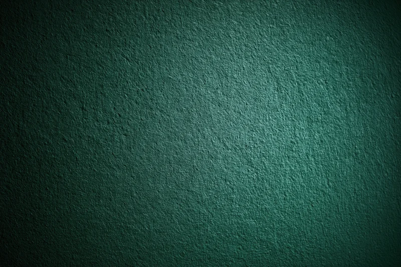 Close-up of a deep forest green textured wall surface with subtle lighting gradient