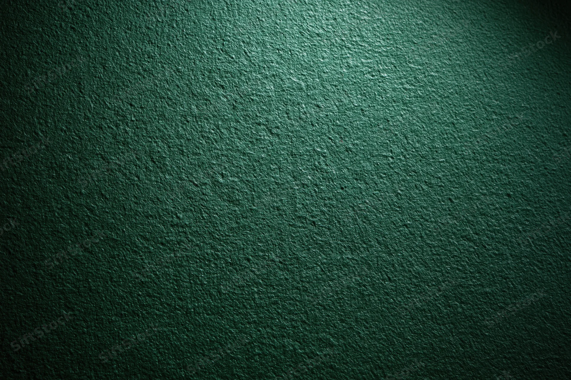 Close-up of deep forest green textured wall surface with spotlight gradient and rough concrete texture