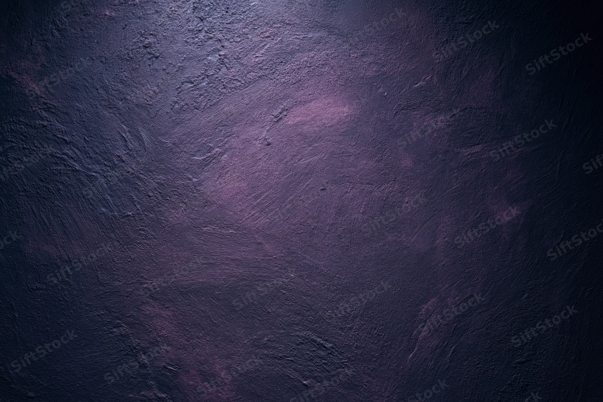 Close-up of rough plastered wall surface with dark purple tones and textured finish