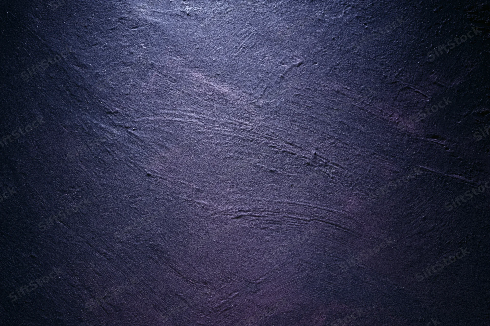 Close-up of rough plastered wall surface with dark blue and purple tones