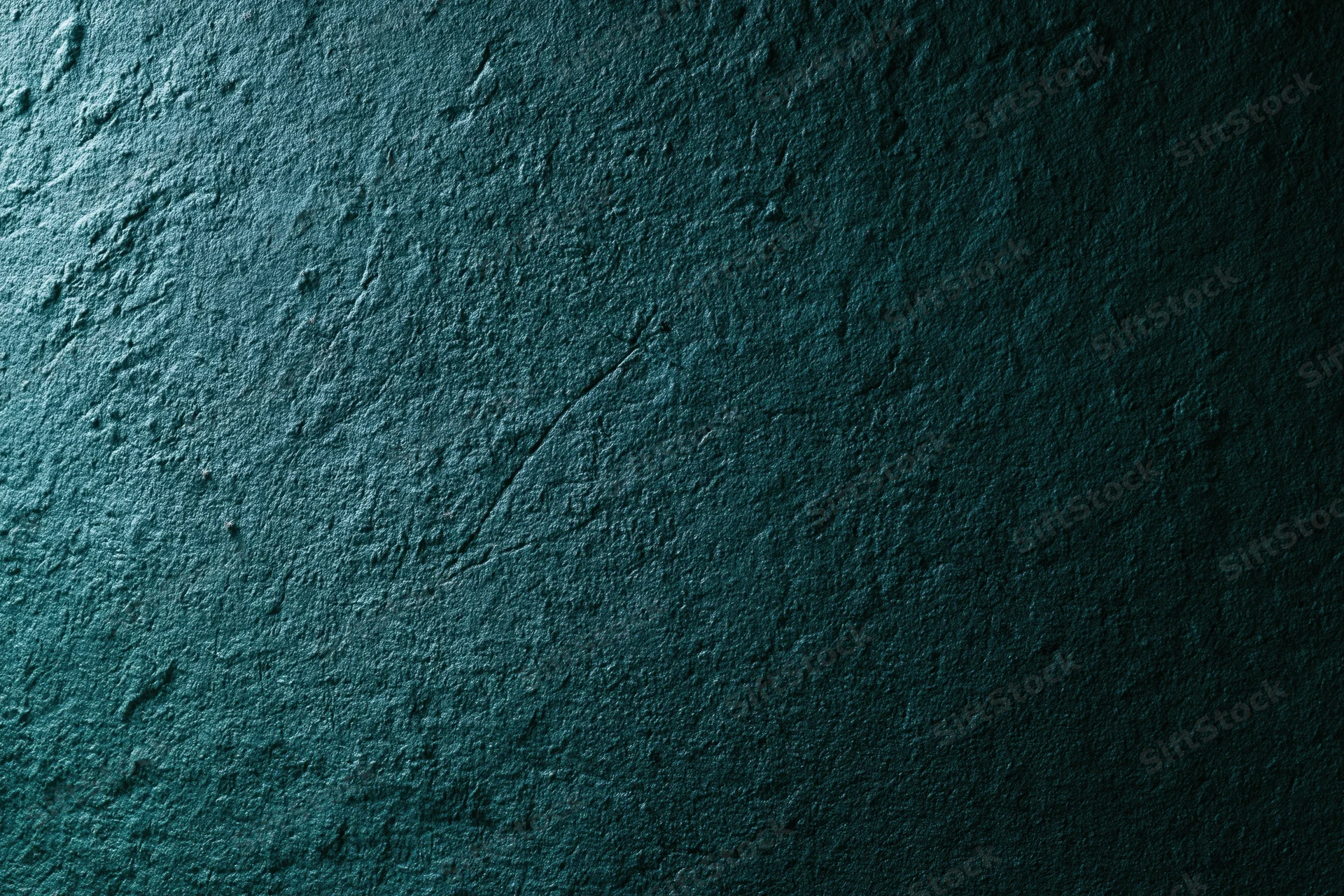 Close-up of rough textured wall surface in dark teal tones with visible cracks and uneven texture