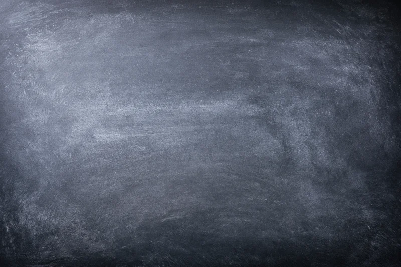 Close-up of a worn chalkboard surface with smudged residue and no writing
