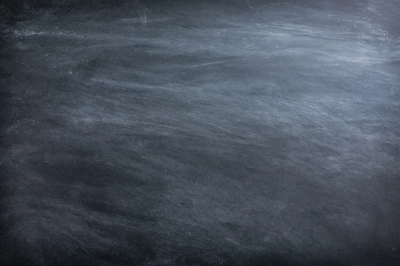 Close-up of a worn chalkboard surface with smudged chalk residue and no writing