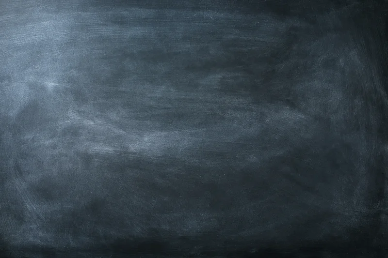 Close-up of a worn chalkboard surface with smudged chalk residue and visible texture