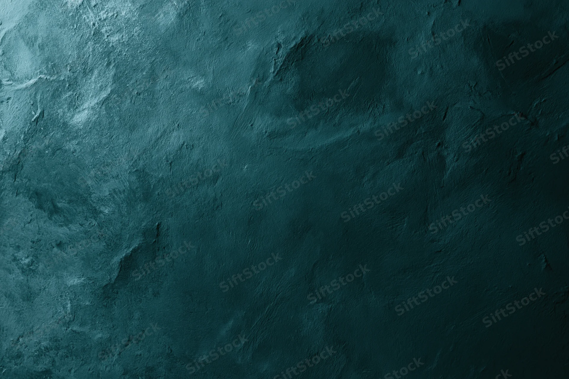 Close-up of a dark teal aged plaster wall surface with rough texture and subtle shadows