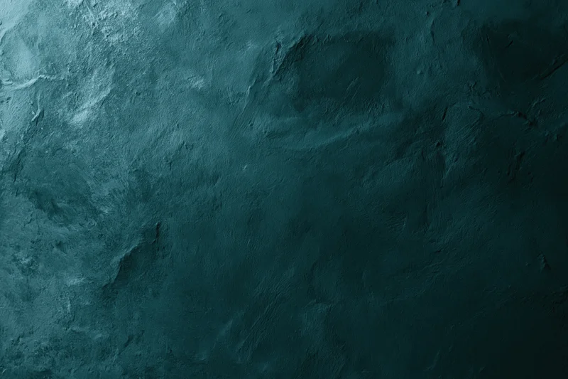 Close-up of a dark teal aged plaster wall surface with rough texture and subtle shadows
