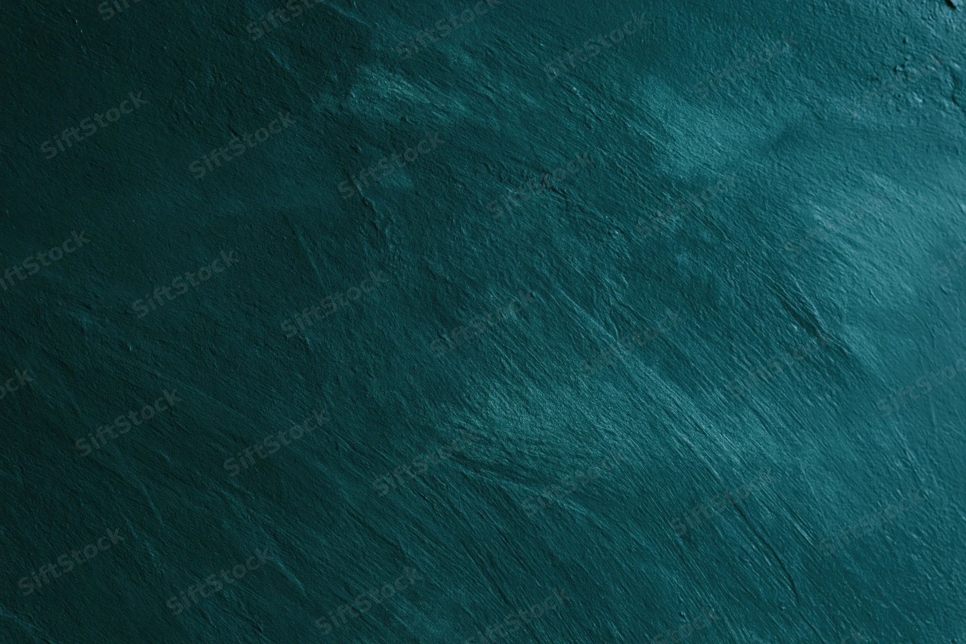 Close-up of aged concrete wall surface with rough texture and dark teal color