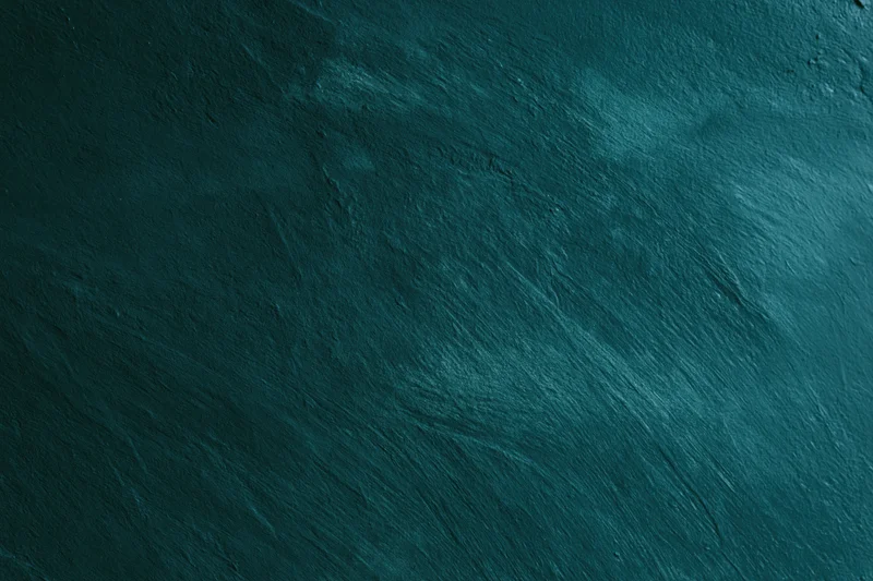 Close-up of aged concrete wall surface with rough texture and dark teal color