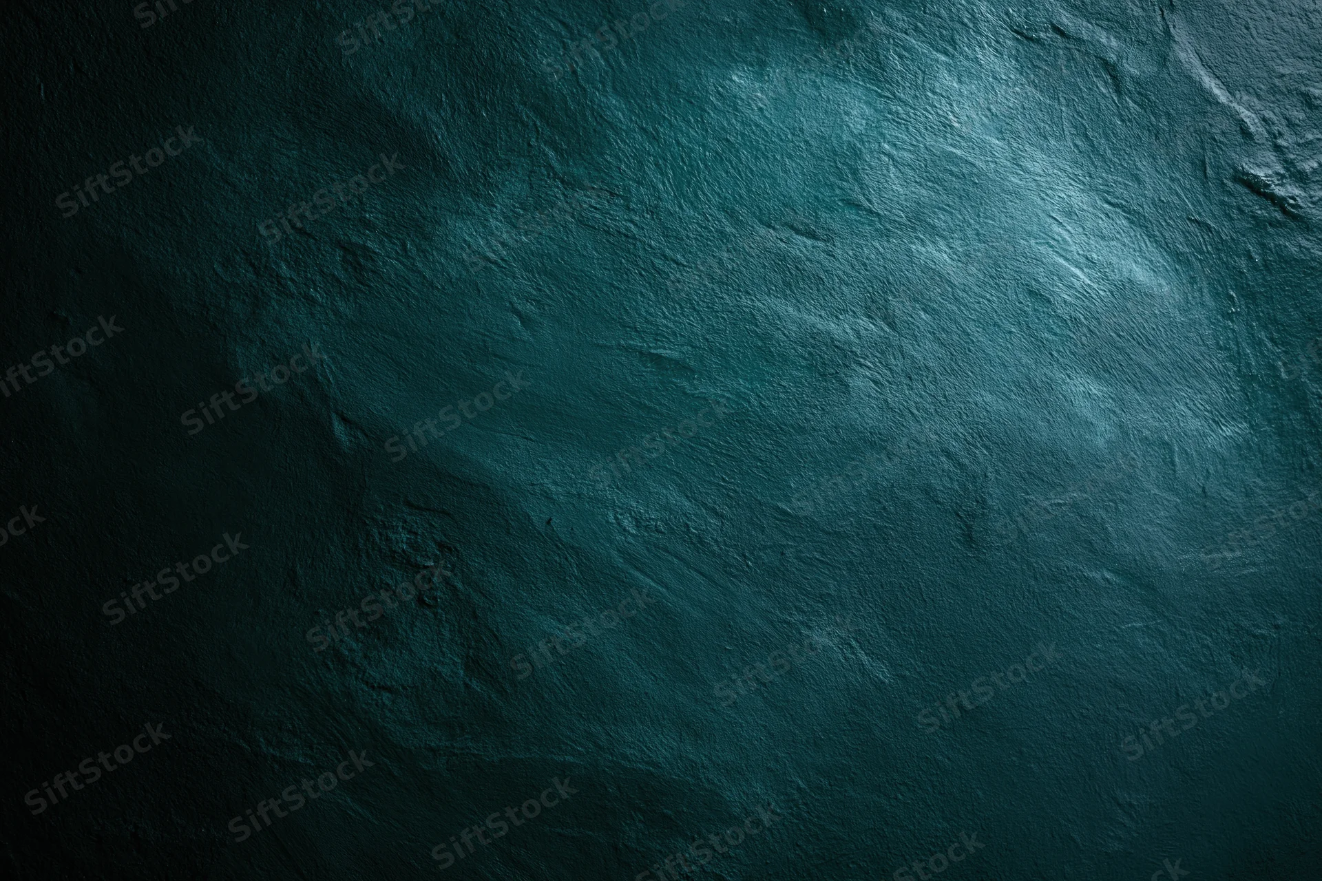 Close-up of a dark teal aged concrete wall surface with rough texture and subtle lighting gradient