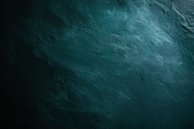 Close-up of a dark teal aged concrete wall surface with rough texture and subtle lighting gradient