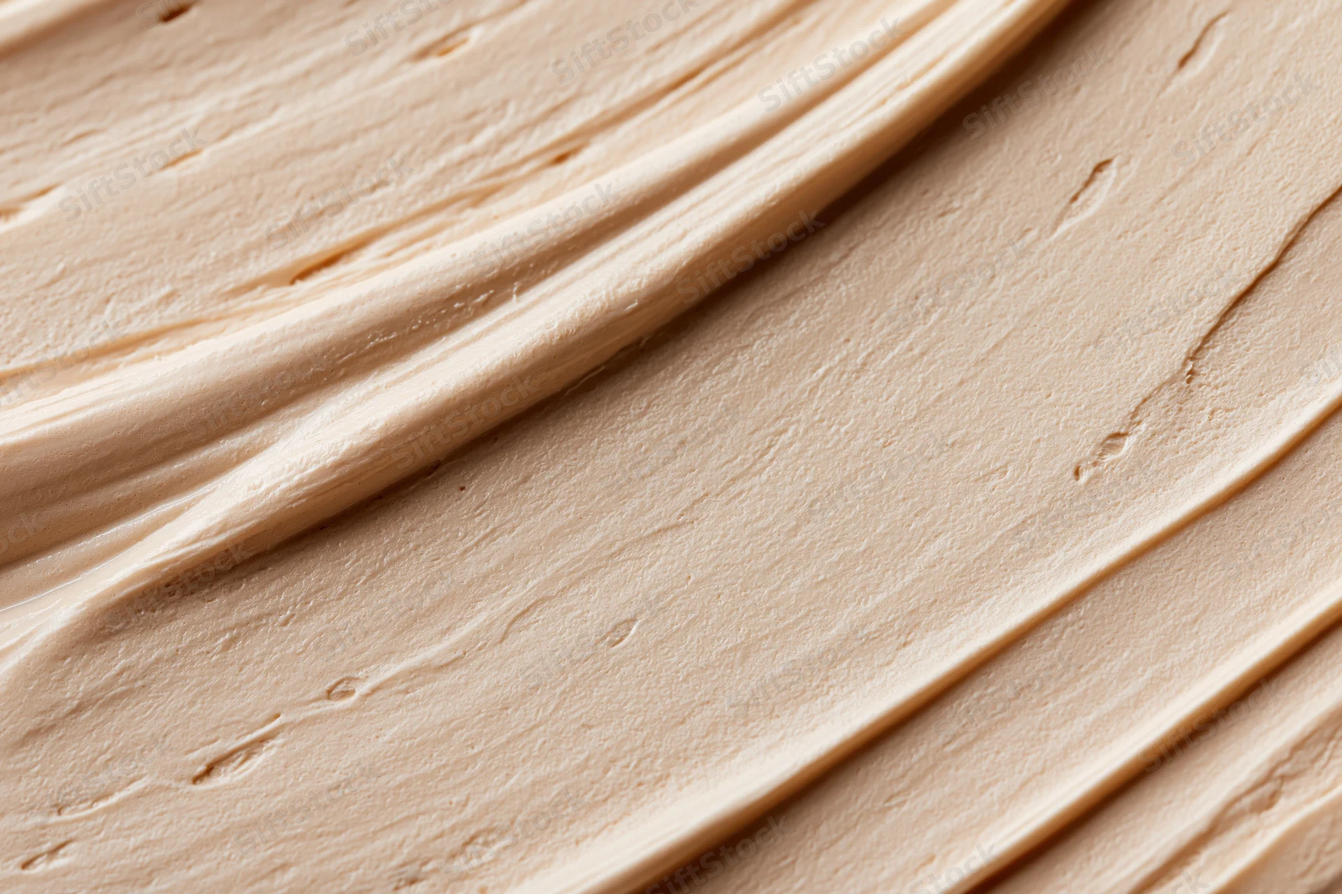 Close-up of smooth beige cosmetic cream texture