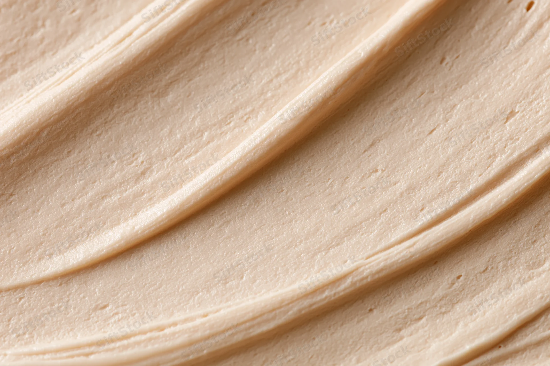 Close-up of smooth beige cosmetic cream texture