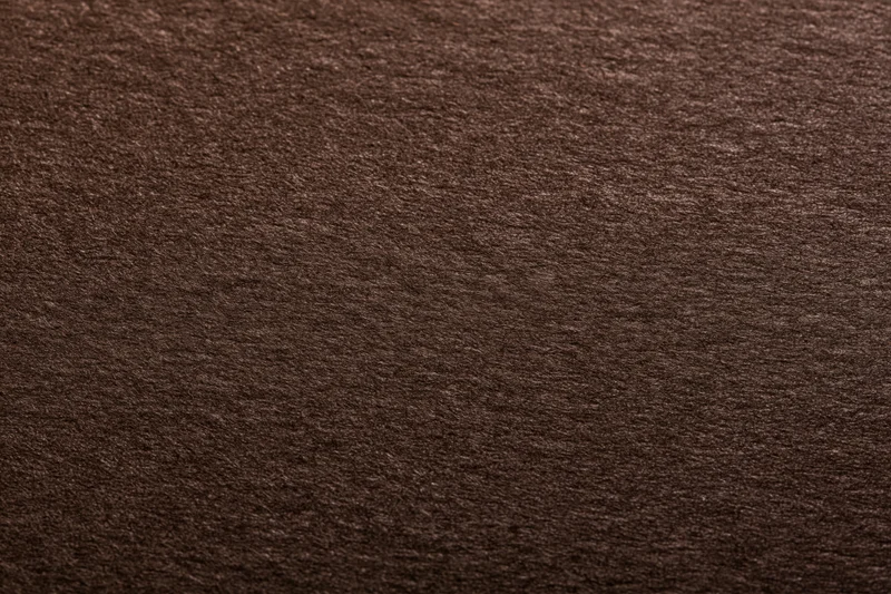 Close-up of dark chocolate brown textured paper surface
