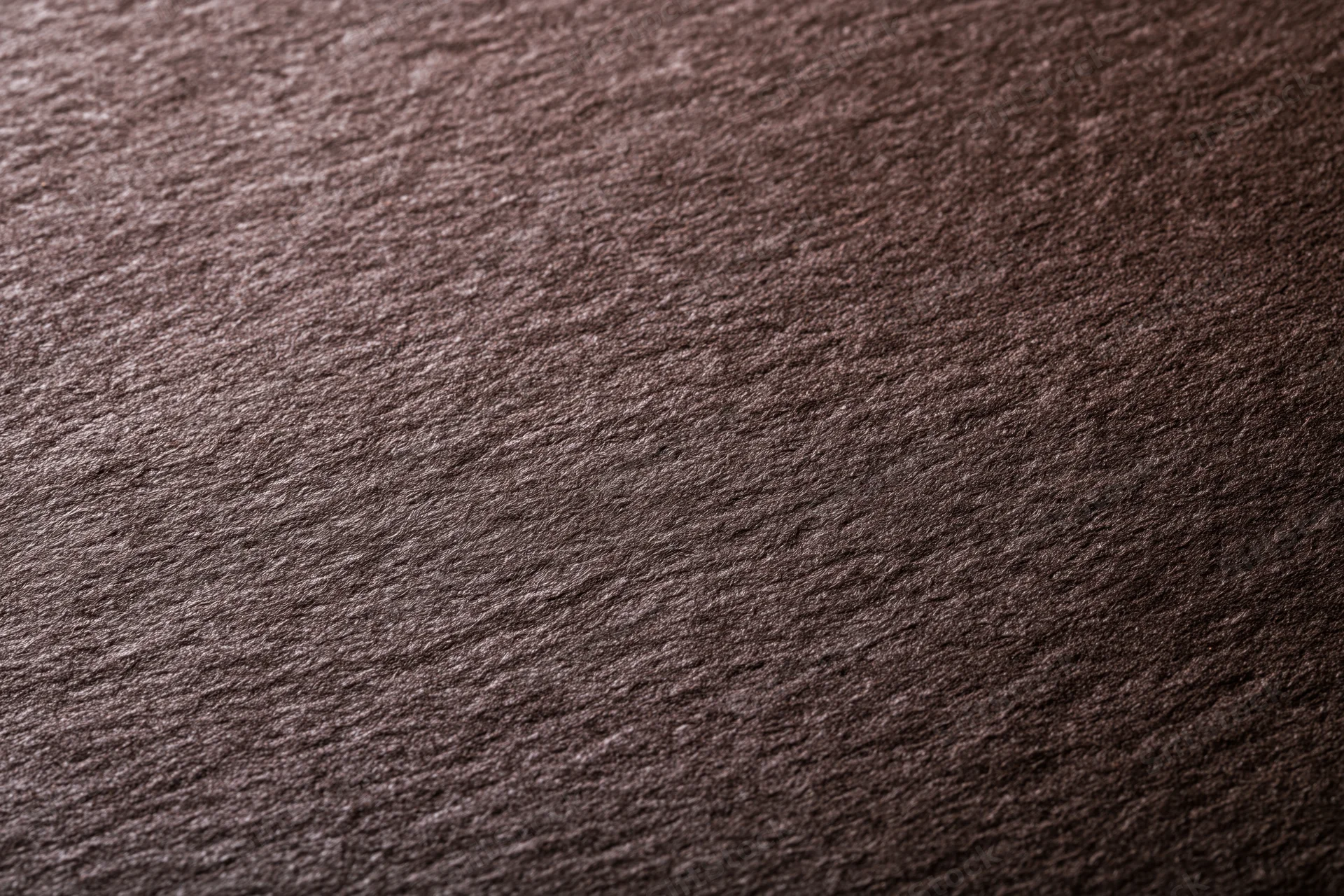 Close-up of dark chocolate brown textured paper surface