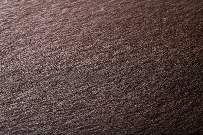 Close-up of dark chocolate brown textured paper surface