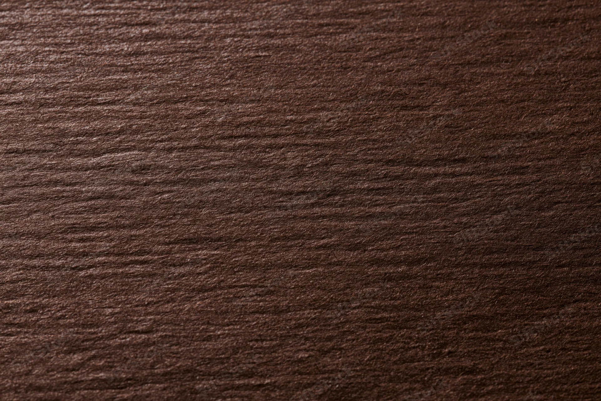 Close-up of dark chocolate brown textured paper surface